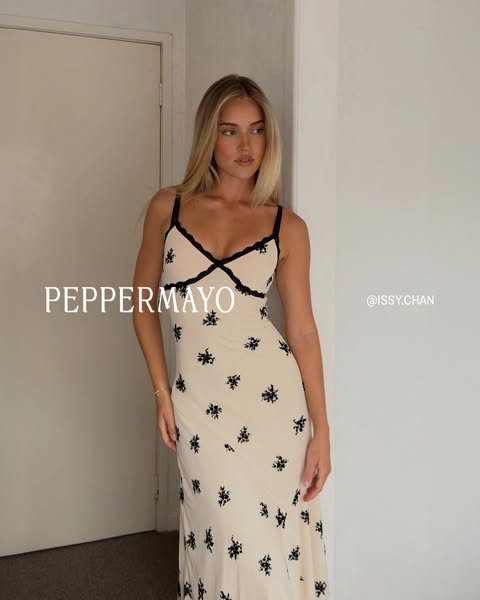 This ad showcases a woman modeling a long, floral dress, and is intended to promote the brand Peppermayo.