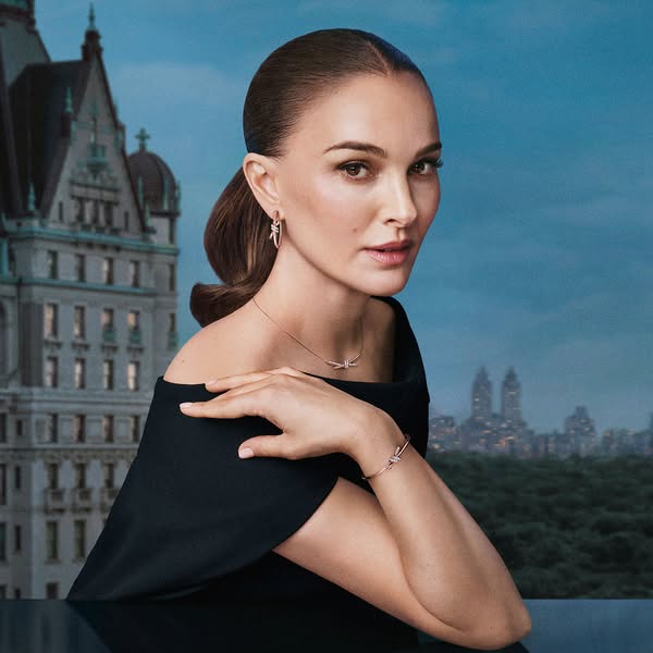 This image ad features Natalie Portman wearing Tiffany & Co.'s Lock collection jewelry in front of a scenic city