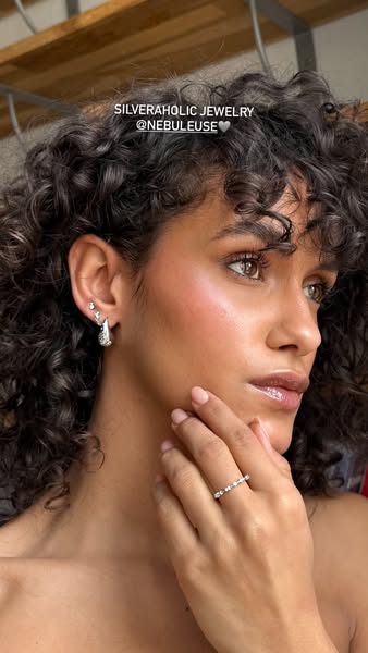 This ad features a woman showcasing jewelry from Silveraholic Jewelry. She is wearing earrings and a ring from the brand