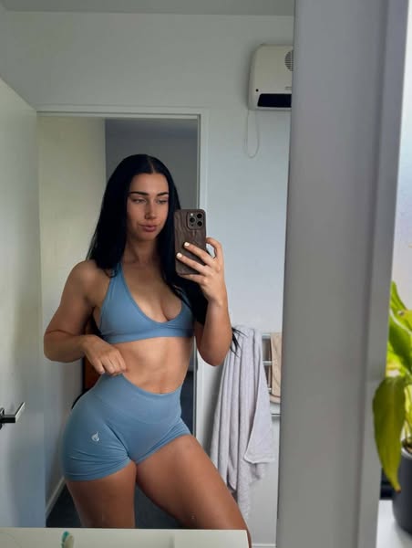 A mirror selfie of a woman wearing workout clothing from a brand called Angel Official. The overall impression is that A