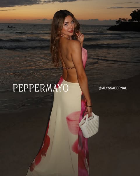 This ad showcases a person wearing a dress from Peppermayo, in front of a sunset ocean backdrop.