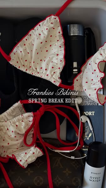 This ad showcases a Frankie's Bikinis swimsuit with a red polka dot pattern alongside a collection of travel essenti