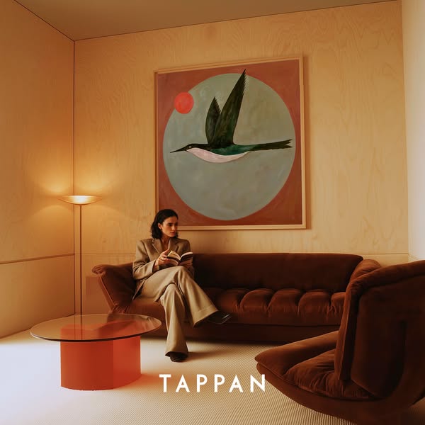 This ad presents a living space furnished with Tappan furniture. A woman sits on the couch, reading a book.