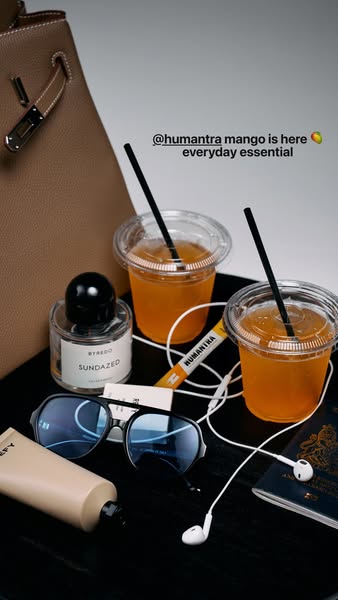 The ad is a product showcase featuring a variety of items on a dark surface, including Humanitra Mango, Byredo Sundazed 