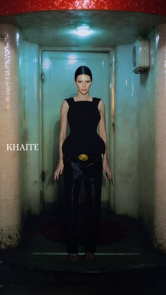 A striking image of model Kendall Jenner wearing KHAITE apparel in a gritty, urban setting, promoting the brand's so