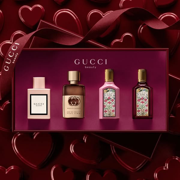 This image ad showcases a Gucci Beauty fragrance set in a maroon box on a matching heart-patterned background.