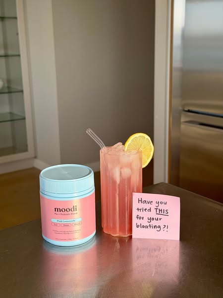 This ad is for Moodi Pink Lemonade. It includes a can of Moodi Pink Lemonade and a glass of the drink. A sticky note ask