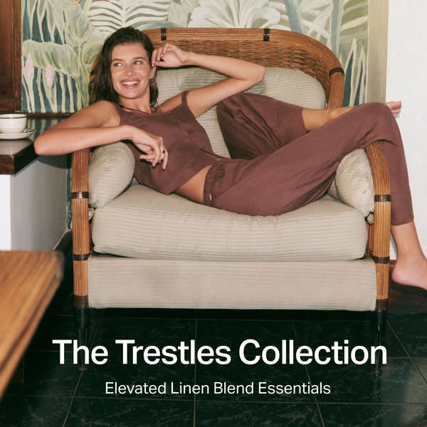 A woman reclines in a linen blend clothing set from The Trestles Collection. The setting implies she is relaxing at home