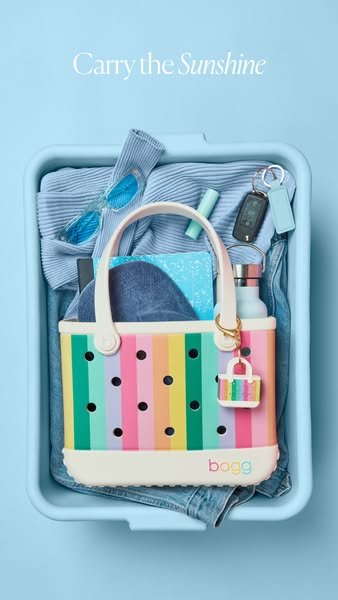 This image ad showcases a colorful Bogg Bag inside a blue tub with various everyday items like sunglasses, a water bottl
