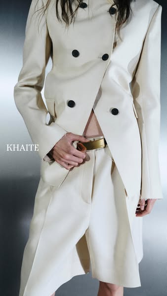 This image ad features a model wearing clothing from the brand Khaite. The model is wearing a cream colored blazer and p