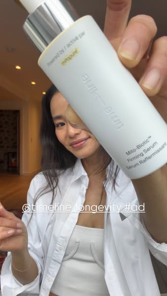This ad features a woman holding the TimeLine Mito-Biotic Firming Serum. The image shows the product and emphasizes the 
