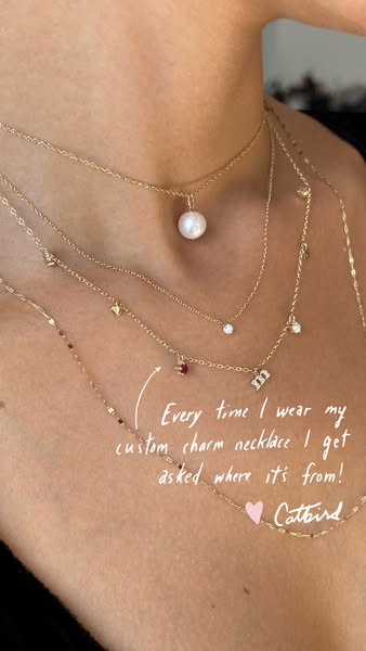 Image ad for Catbird jewelry. The image shows a close up of a person's chest wearing multiple gold necklaces of vary