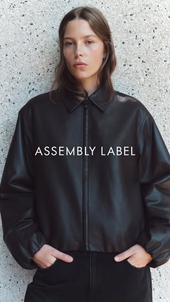 This ad features a model wearing a black jacket from Assembly Label. The ad showcases the jacket's minimalist design
