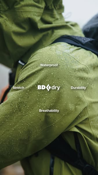 A close-up shot shows water droplets on a green jacket, highlighting its waterproof and breathable qualities.