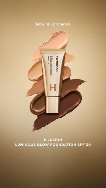 This ad showcases Hourglass's Illusion Luminous Glow Foundation SPF 30, now available in 32 shades. The ad uses a vi