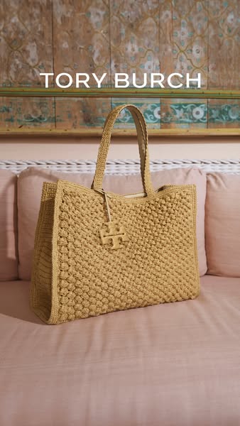 This ad features a Tory Burch handbag in a staged lifestyle shot. The purse is woven and a neutral tan color, and appear