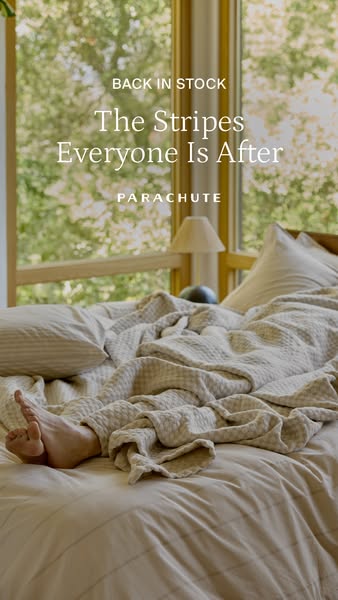 A lifestyle ad featuring a bed covered in striped bedding from Parachute. The ad announces that the striped bedding is b