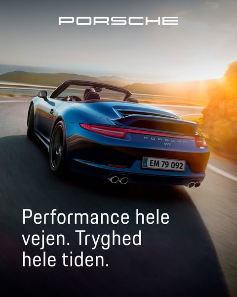 This image ad showcases a blue Porsche 911 convertible driving on a road at sunset. The ad emphasizes the brand's co