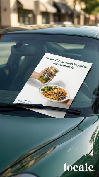 A photo of a Locale ad placed on a car's windshield. The ad showcases a person holding a mason jar filled with a sal