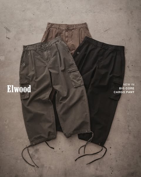 This ad showcases the Elwood brand's new cargo pants in three different colors. The pants are arranged on a concrete