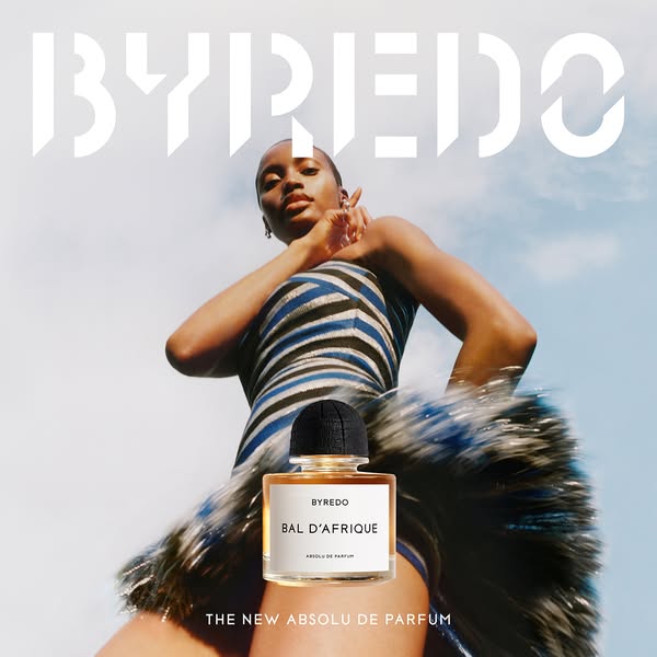 This ad features a woman posing in a fashionable outfit against a bright blue and white sky, while showcasing a bottle o