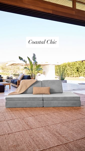 This image ad features a gray Lovesac Sactional modular couch in an outdoor living space. The simple design aesthetic an