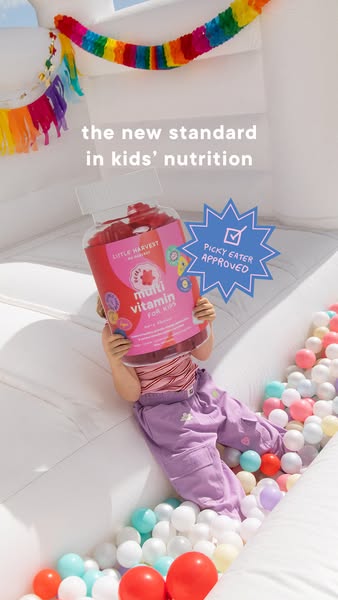 Image ad for Little Harvest kids' multivitamins featuring a child holding the product in front of their face in a ba