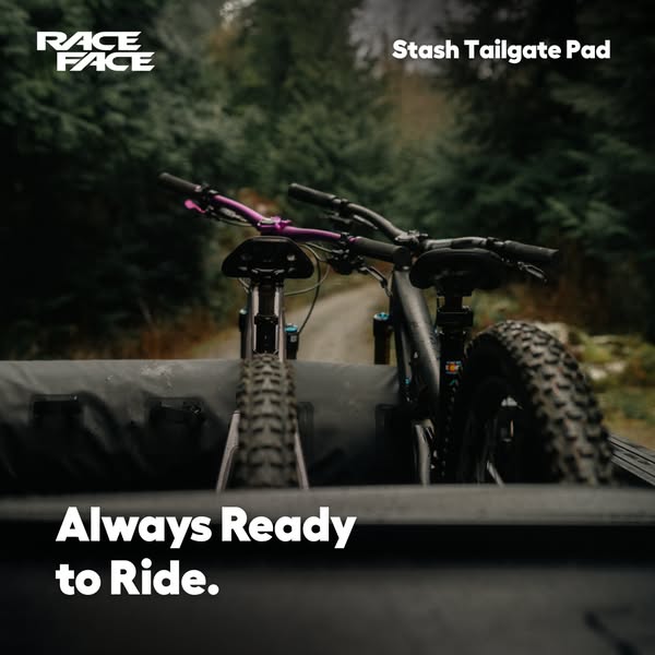 This ad for the Race Face Stash Tailgate Pad features an image of two mountain bikes secured on the tailgate pad of a tr
