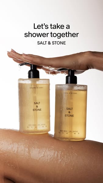 This ad features a photo of the SALT & STONE body wash. A hand is pressing down on the pumps of two body wash bottle