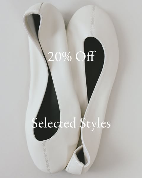 An image ad featuring a pair of white ballet flats with a discount offer.