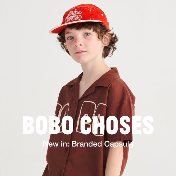 This ad features a person modeling products from the Bobo Choses branded capsule. The ad showcases a red baseball cap an