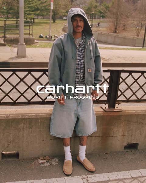 The ad features a man standing in a city setting wearing Carhartt clothing. The ad showcases the brand Carhartt.