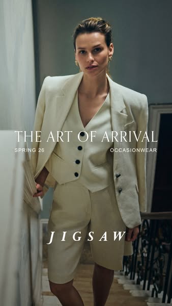 The image features a model wearing a light-colored suit and shorts outfit from Jigsaw's Spring 26 collection, promot