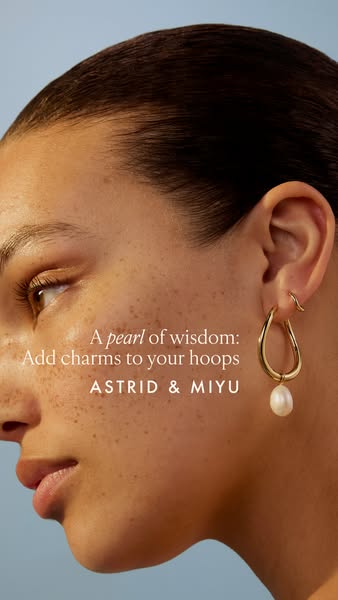 This ad features a close-up shot of a person wearing a gold hoop earring with a pearl charm. The ad copy encourages view