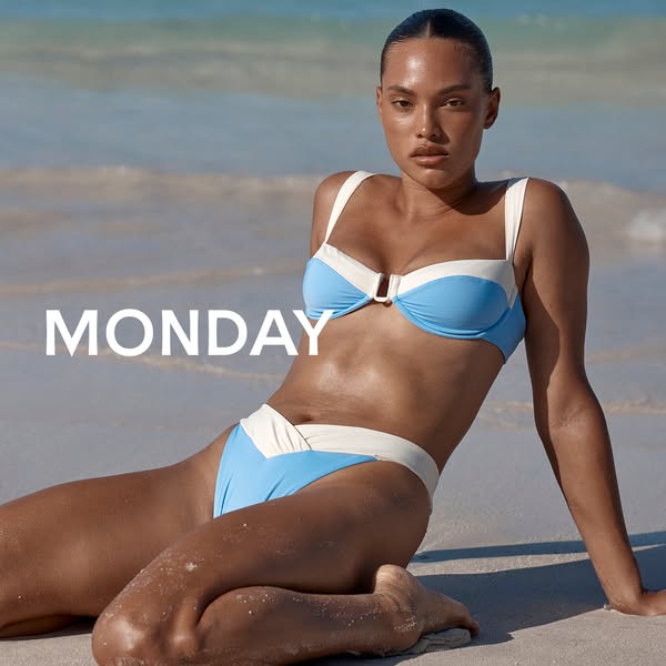 A woman is sitting on a beach wearing a blue and cream colored bikini.