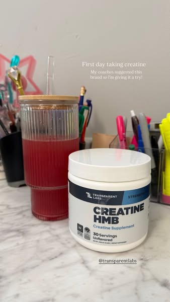 The image shows a glass filled with red liquid next to a container of creatine supplement. Text over the image indicates