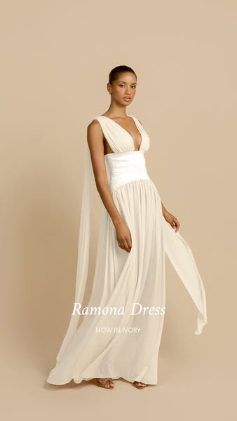 This image ad features a model wearing a long, flowing, ivory dress. The brand and product name are displayed in a simpl