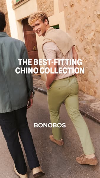 An image ad for Bonobos chinos. The ad features two people walking side by side on a cobblestone street, showcasing the 