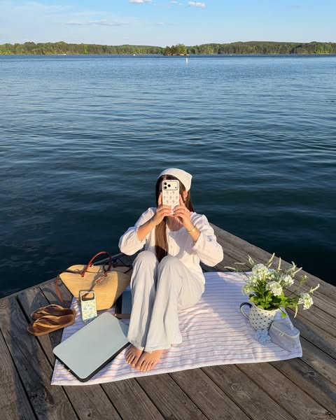 An image ad featuring a woman sitting on a dock by the water, promoting a laptop. The image also features several aesthe