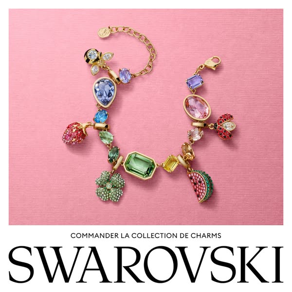 This image ad for Swarovski showcases a gold charm bracelet with various colorful crystal charms like a strawberry, wate
