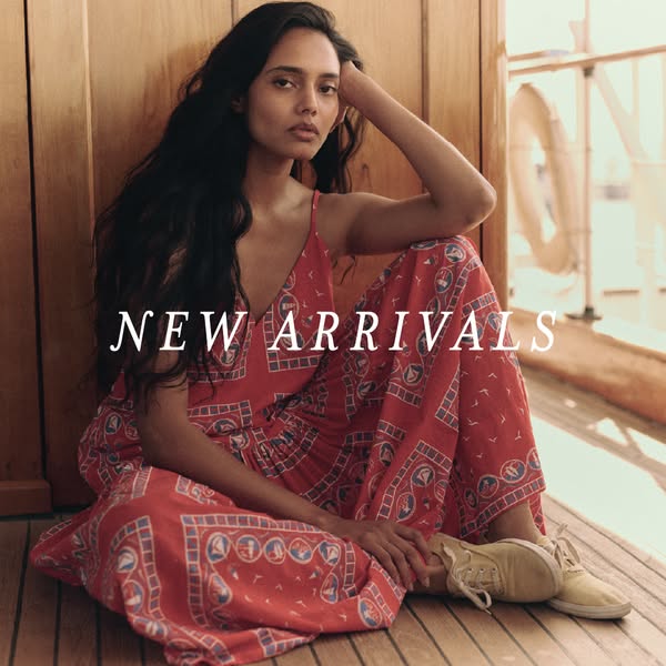 This image ad showcases a woman modeling a red dress with a pattern while sitting on a boat. The ad promotes new arrival