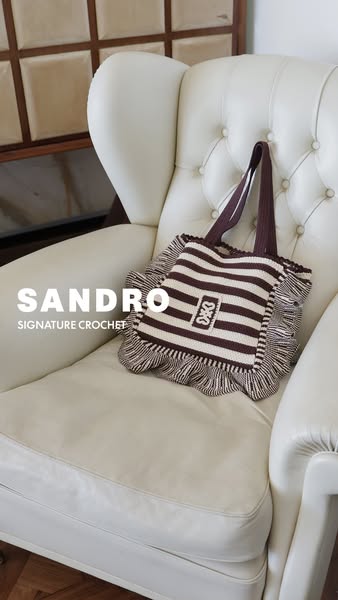 An image ad displaying a Sandro crochet bag, with the brand and product name overlaid on the image.