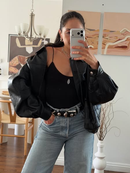 This ad features an image of a person taking a selfie in a mirror wearing a stylish outfit, showcasing a casual and tren