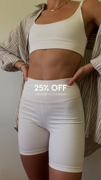 This image ad promotes organic activewear with a 25% discount, featuring a model wearing a matching sports bra and biker