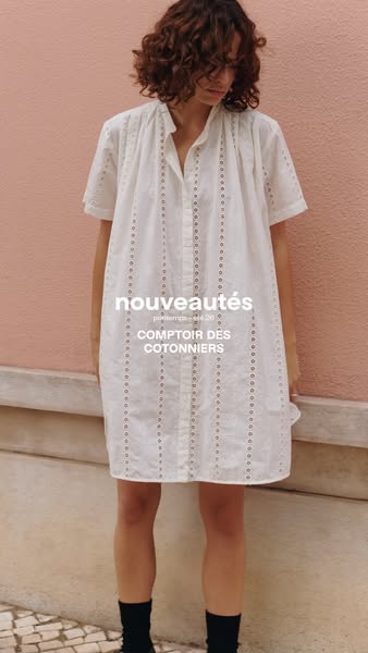This ad showcases the brand Comptoir Des Cotonniers and features a model wearing a white cotton short-sleeve eyelet dres