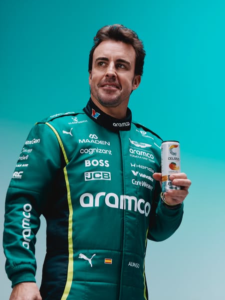 Image ad featuring Aston Martin Aramco Formula One Team driver Fernando Alonso holding a can of Celsius energy drink. Th