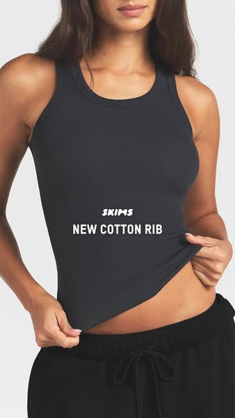 This ad showcases the SKIMS new cotton rib tank top. The ad features a model wearing the black tank top and tugging on t