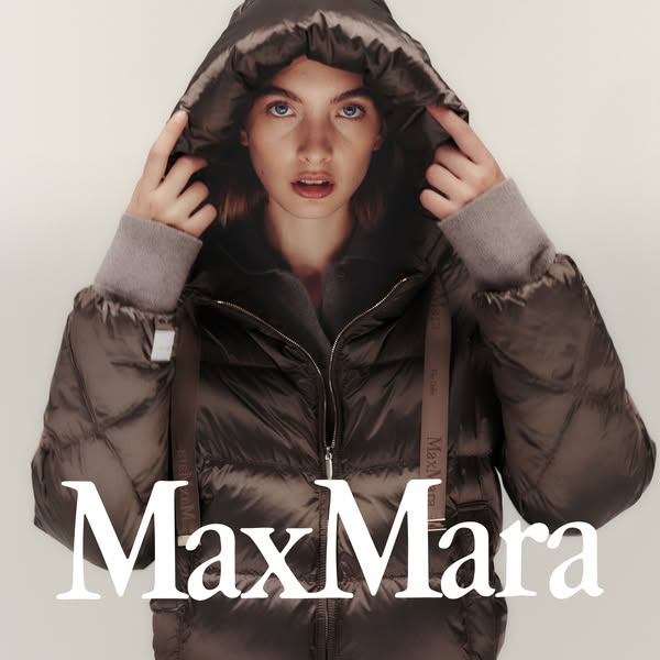 A portrait of a woman wearing a brown Max Mara puffer jacket with a hood, with the brand name in white text across the l