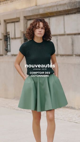An advertisement for Comptoir des Cotonniers clothing, featuring a woman wearing an green skirt and dark green shirt.