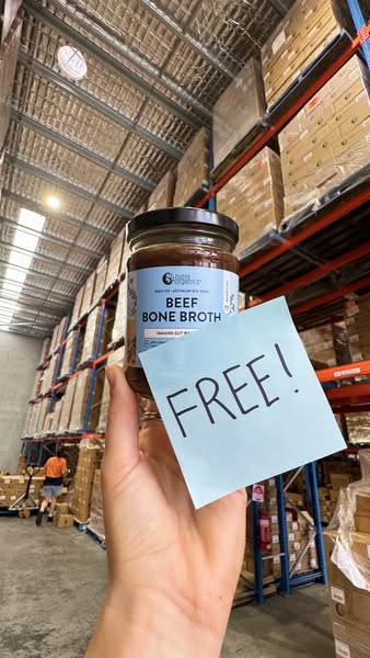 This ad features a hand holding a jar of beef bone broth against a warehouse backdrop. A sticky note reading 'FREE!&
